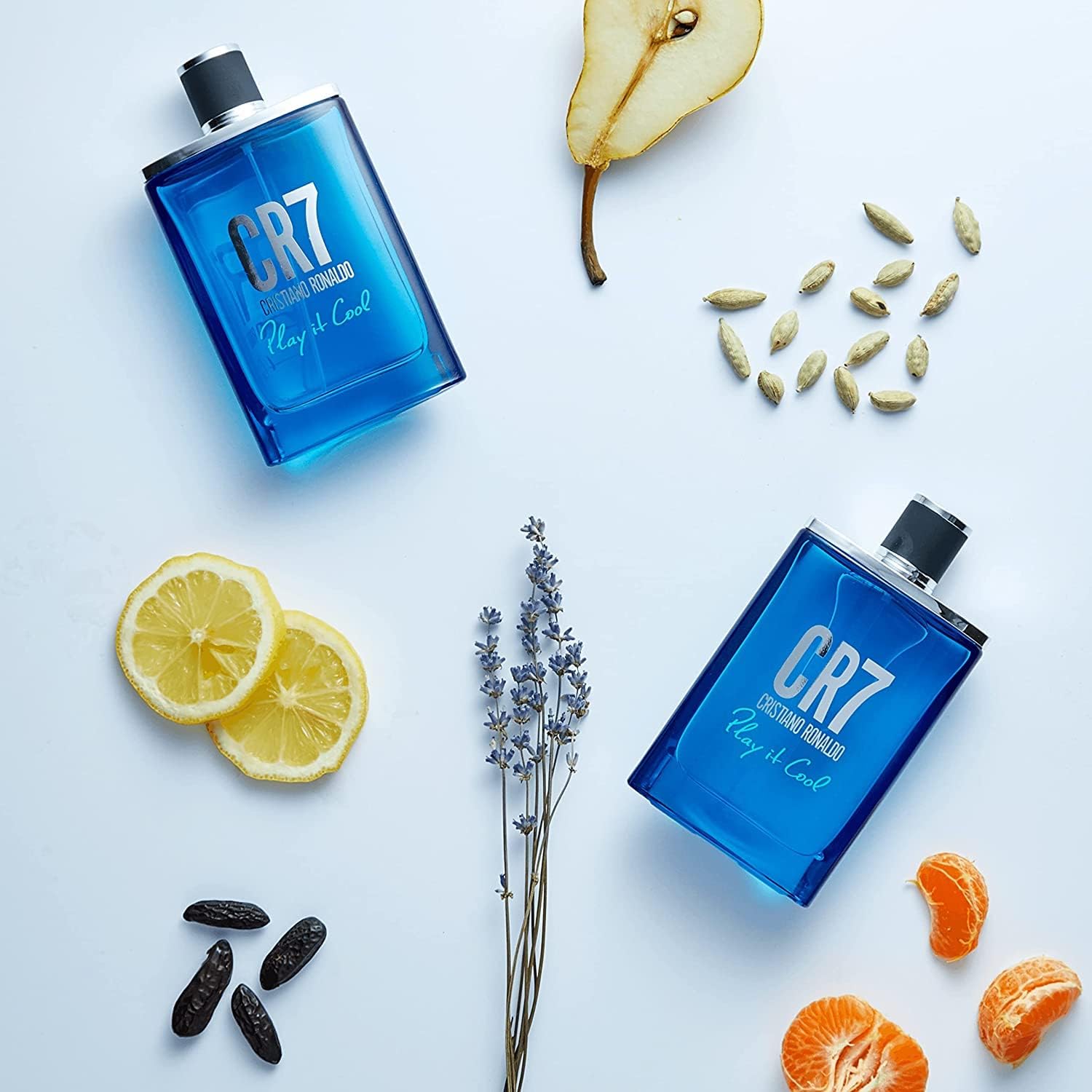 Group of blue bottles with lemons and fruit showcasing CR7 Cristiano Ronaldo Play It Cool Eau De Toilette, a light and fresh fragrance for men. Ideal for everyday wear, this aromatic and citrusy scent captures the essence of an active and energetic man.