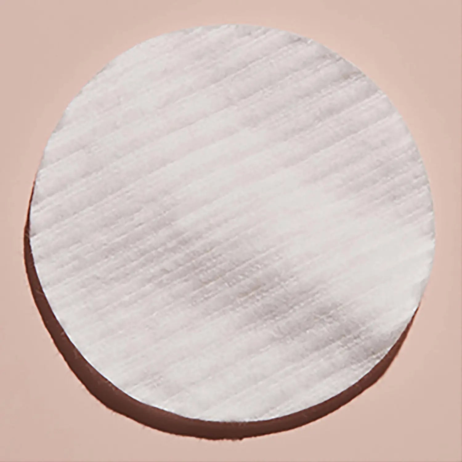 Eve Lom Rescue Peel Pads (60 Pads): A round white circle with a textured surface, representing the exfoliating and resurfacing treatment that gently buffs away dead skin, revealing a smoother, brighter, and revitalized complexion.